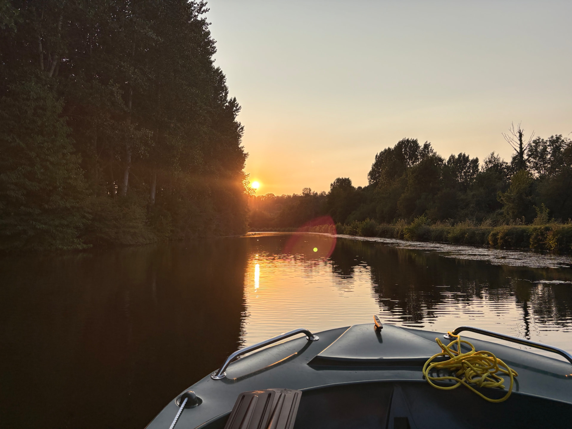 Coucher de soleil doré sur la Somme depuis la proue d'une barque